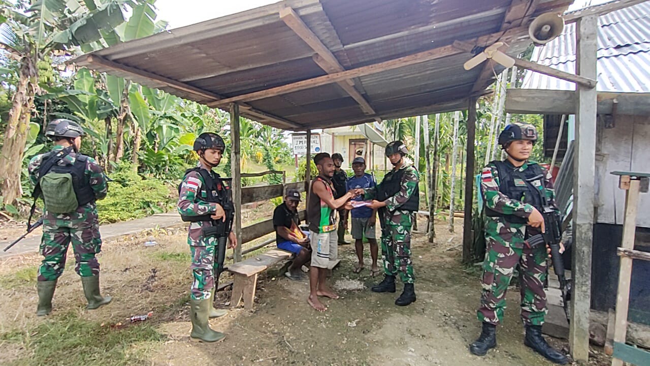 Satgas Pamtas RI-PNG Yonif 126/KC Pos Kalilapar membagikan seragam sekolah dan buku tulis untuk anak-anak sekolah di Kampung Sach