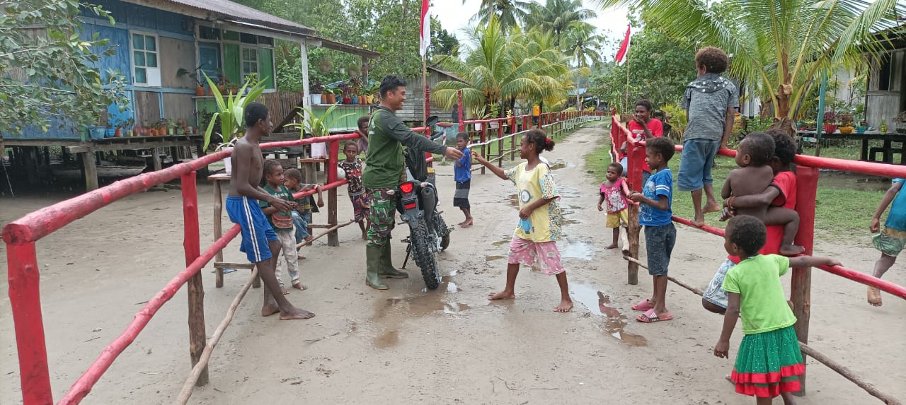 Serma Didik yang memberikan permen kepada anak-anak di Kampung Atapo, Distrik Mimika Barat, Kabupaten Mimika