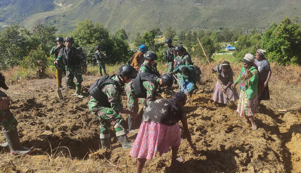Satgas Yonif Mekanis 203/AK bersama masyarakat Lanny Jaya membuka lahan perkebunan yang berada di Desa Umbana