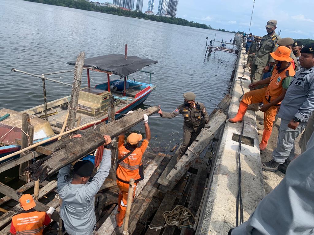 Personel Kapal Catamaran-504 dan RHIB 87-11 Bakamla RI menertibkan dermaga liar yang memanfaatkan tanggul pengamanan pantai DKI Jakarta