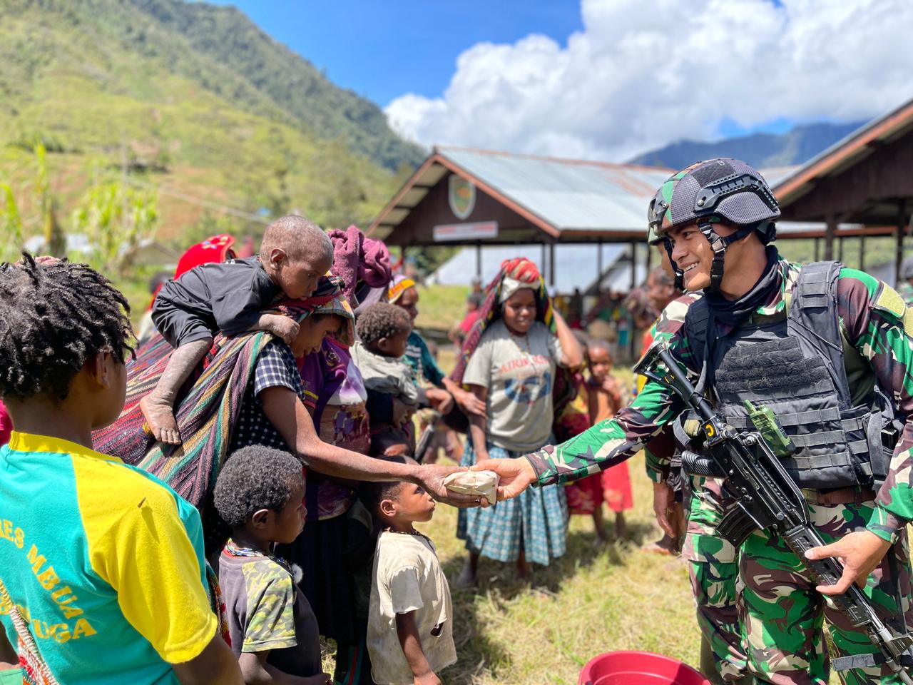 Personel Pos Kotis Mbua Satgas Yonif Raider 321/GT/13/1 Kostrad berbagi ratusan bungkus makanan dalam kegiatan perjamuan kasih