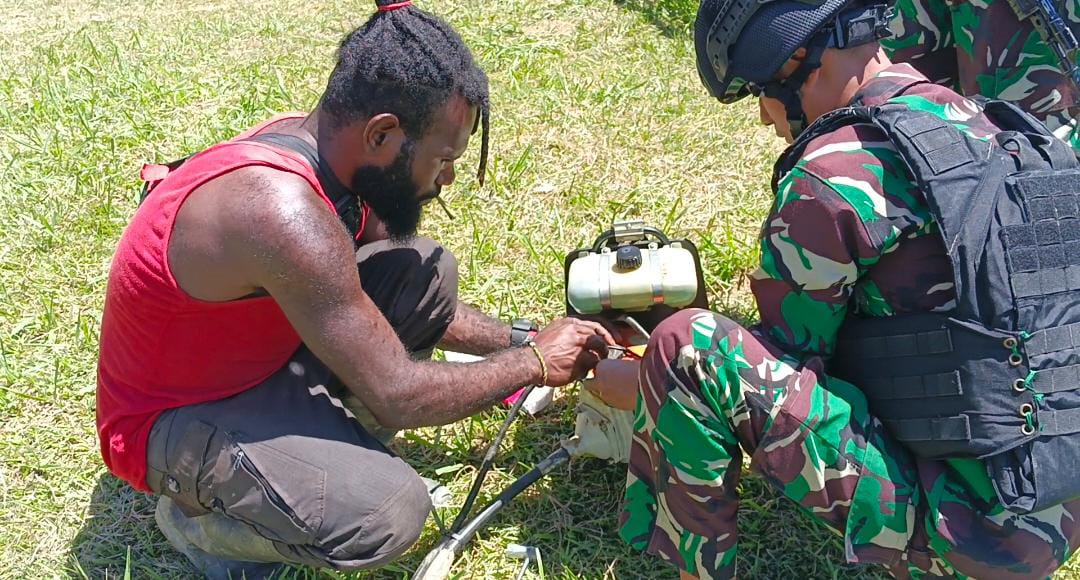 Satgas Yonif Raider 200/BN Pos Eragayam saat memberikan bantuan perbaikan mesin rumput yang rusak di Kampung Eragayam, Distrik Eragayam