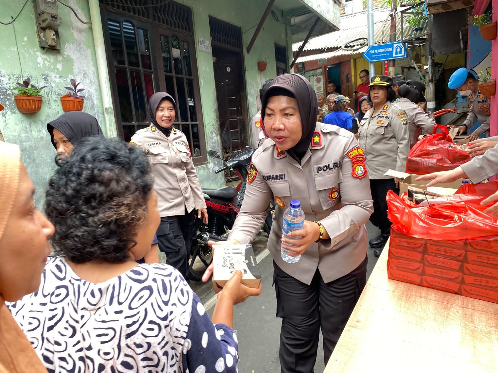 Wakapolres Metro Jakarta Timur AKBP Burhanuddin membagikan nasi box kepada warga masyarakat di Jl. Jatinegara Barat RW 08 Kel. Kampung Melayu