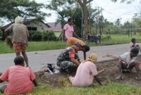 Babinsa Koramil 07/Mapurujaya Kodim 1710/Mimika, Sertu Tangkas Budiono bersama warga melaksanakan kerja bakti di halaman Balai Kampung Mwuare