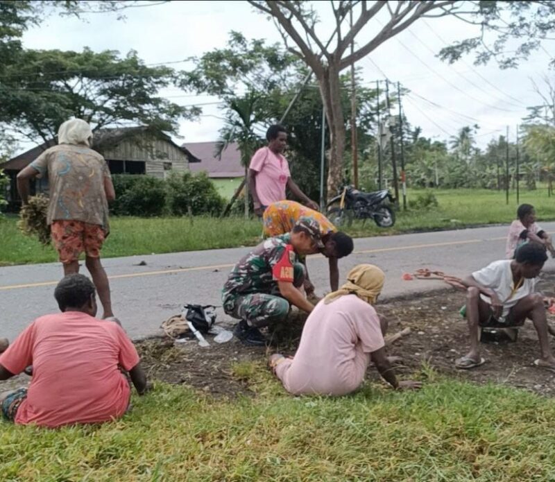 Babinsa Koramil 07/Mapurujaya Kodim 1710/Mimika, Sertu Tangkas Budiono bersama warga melaksanakan kerja bakti di halaman Balai Kampung Mwuare