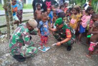 Babinsa Koramil 1710-07/Mapurujaya Kodim 1710/Mimika, Sertu Sufriadi dan Pratu Yakobus Kowet melaksanakan kegiatan Pemberian Makanan Tambahan