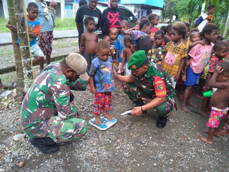 Babinsa Koramil 1710-07/Mapurujaya Kodim 1710/Mimika, Sertu Sufriadi dan Pratu Yakobus Kowet melaksanakan kegiatan Pemberian Makanan Tambahan