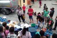 Sertu Slamet Jaya Abadi (Babinsa Koramil 1710-07/Mapurujaya) membantu membagikan bantuan air bersih kepada warga Kp. Pomako