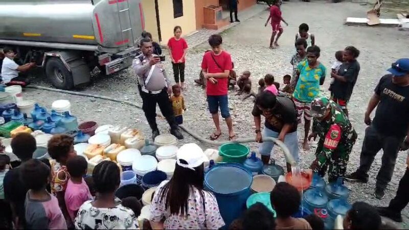 Sertu Slamet Jaya Abadi (Babinsa Koramil 1710-07/Mapurujaya) membantu membagikan bantuan air bersih kepada warga Kp. Pomako