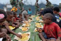 Satgas Pamtas Kewilayahan Yonif 715/Mtl dalam rangka memperingati hari Natal 2024 melaksanakan gotong royong dan makan bersama