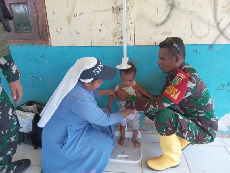 Bintara Pembina Desa (Babinsa) Koramil 1710-06/Agimuga Koptu Yohanes Naibobe bersama-sama petugas kesehatan