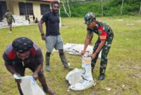 Babinsa Posramil 1714-06 Tingginambut, Kodim 1714/Puncak Jaya Pratu Giovani membantu perangkat kampung pendistribusian beras