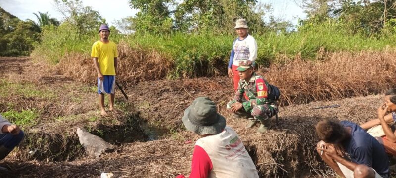 Babinsa Koramil 1710-03/Kuala Kencana, Sertu Abraham Bartkombawa bersama petani binaan melaksanakan kerja bakti