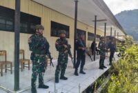 Personel Satgas Yonif 715/Mtl dan Brimob BKO Polda Papua bersinergi untuk mendukung penuh program pemerintah yang ada dan menjaga siswa-siswi