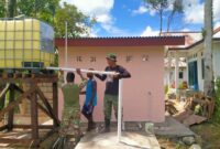 Satgas TMMD bersama warga setempat melaksanakan tahap pemasangan tandon air sebagai bagian dari pembangunan sumur bor