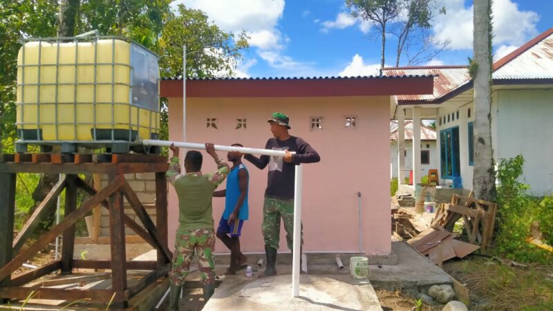 Satgas TMMD bersama warga setempat melaksanakan tahap pemasangan tandon air sebagai bagian dari pembangunan sumur bor