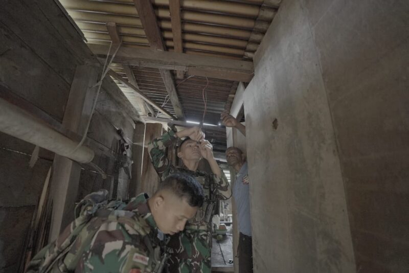 Satgas Pamtas Yonif 715/Motuliato membantu warga dalam memperbaiki instalasi listrik jalan yang rusak di Kampung Tirineri Distrik Mulia