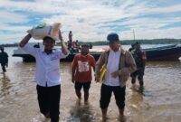 Anggota Babinsa Koramil 1710-01/Kokonao, Sertu Hendrik Renyaan mendampingi proses penyaluran bantuan beras dari Bulog kepada masyarakat