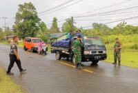 Babinsa Koramil 1710-07/Mapurujaya membagikan bendera merah putih kepada masyarakat