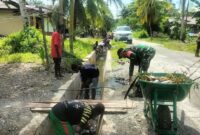 Babinsa Koramil 1710-07/Mapurujaya Serka Selamet Riyadi ajak warga binaan kerja bakti bersihkan parit di Kp. Ayuka, Distrik Mimika Timur Jauh