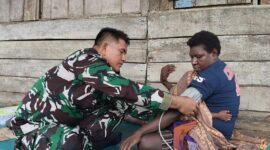 Senyum bahagia terpancar dari wajah Ibu Modesta Akarepia saat menerima layanan kesehatan yang diberikan oleh personel Satgas TMMD