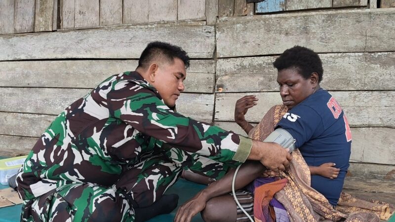 Senyum bahagia terpancar dari wajah Ibu Modesta Akarepia saat menerima layanan kesehatan yang diberikan oleh personel Satgas TMMD