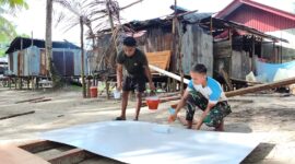Satgas TMMD ke-128 Kodim 1710/Mimika melaksanakan pengecatan triplek yang akan digunakan sebagai plafon pada MCK umum di Kampung Keakwa