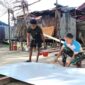 Satgas TMMD ke-128 Kodim 1710/Mimika melaksanakan pengecatan triplek yang akan digunakan sebagai plafon pada MCK umum di Kampung Keakwa