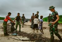 Personel Satgas TMMD ke-128 Kodim 1710/Mimika melaksanakan aksi bersih pantai bersama masyarakat di Kampung Keakwa