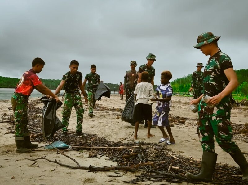 Personel Satgas TMMD ke-128 Kodim 1710/Mimika melaksanakan aksi bersih pantai bersama masyarakat di Kampung Keakwa